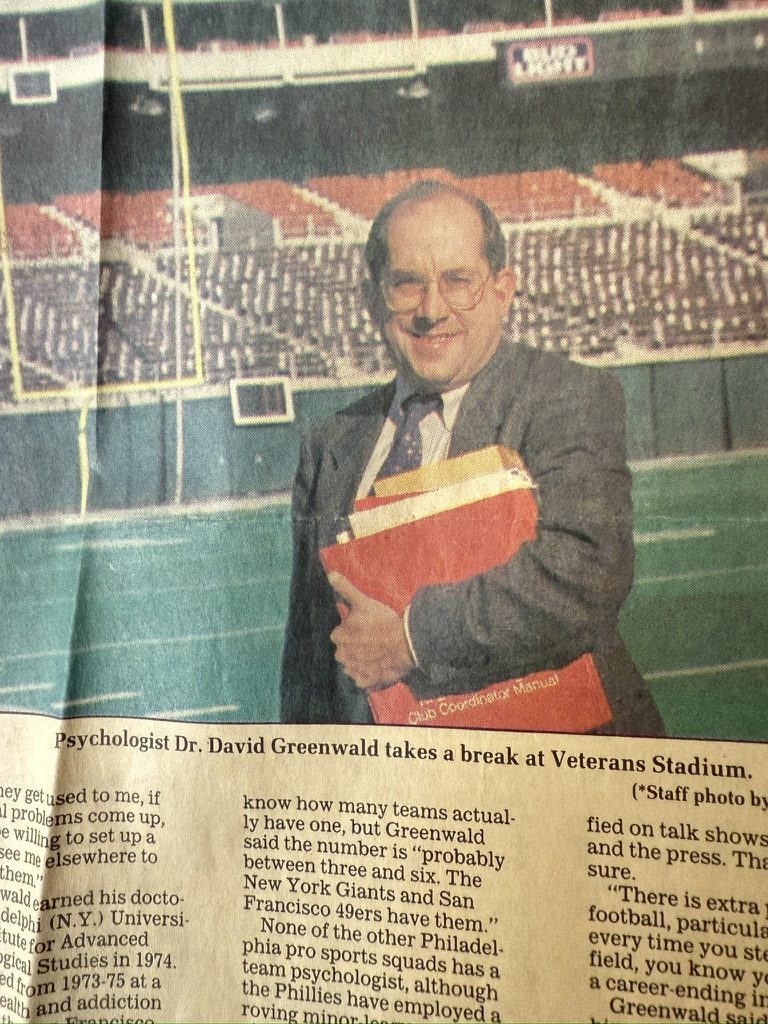 A newspaper photo of David holding a red binder at Veterans Stadium
