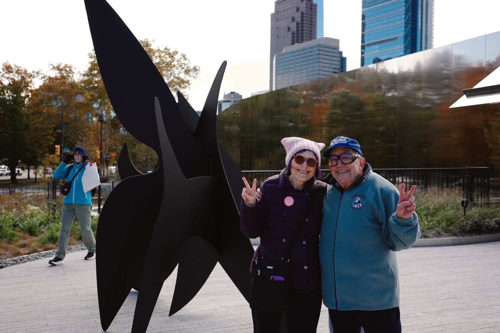 David and a woman making peace signs in front of a black sculpture