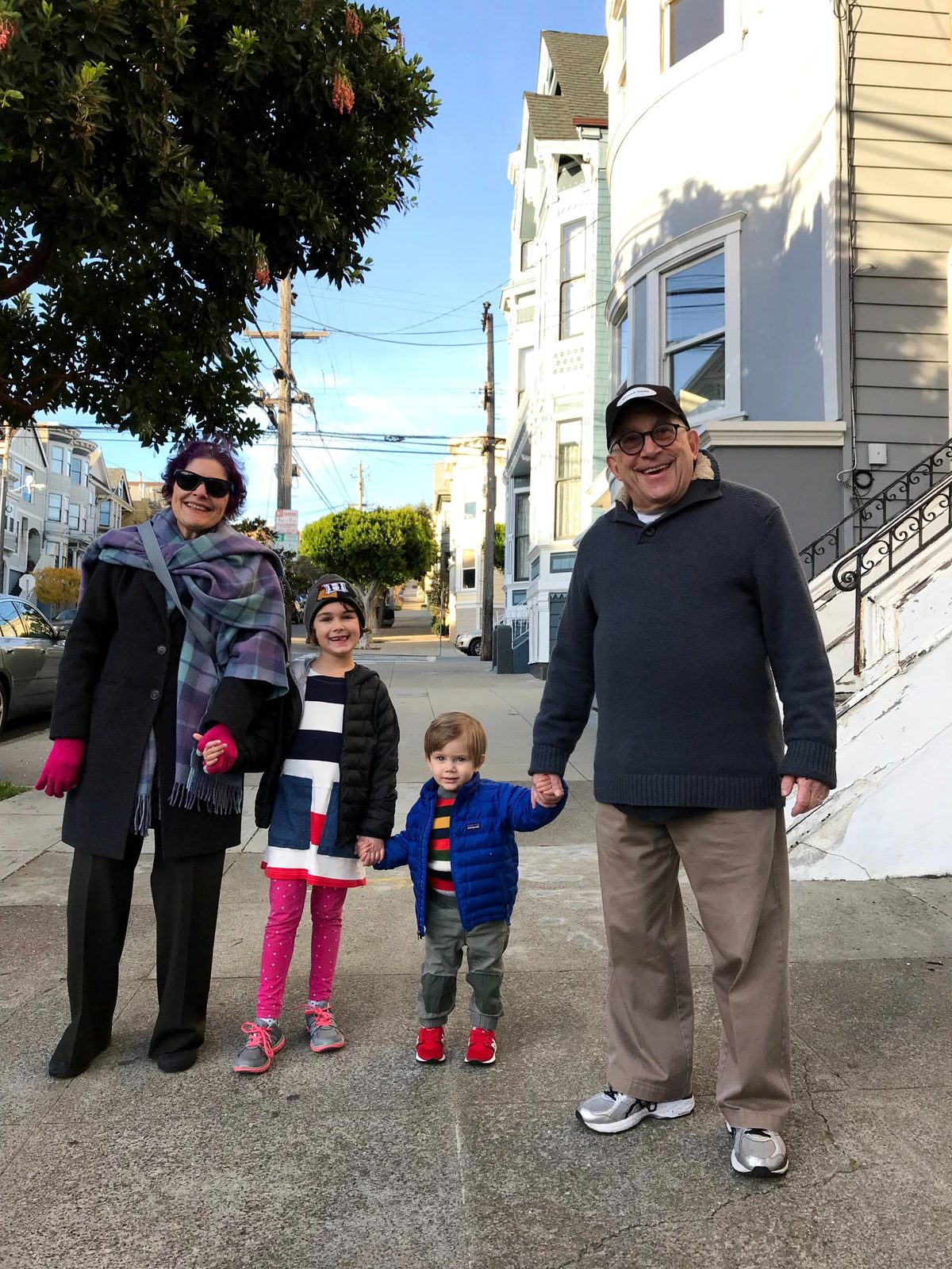 David and a woman holding hands with a girl and a toddler on a San Francisco street